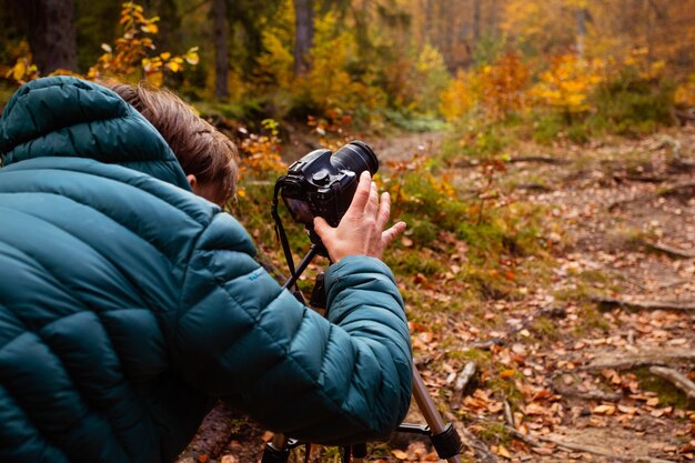 Photo full length of man holding camera in forest