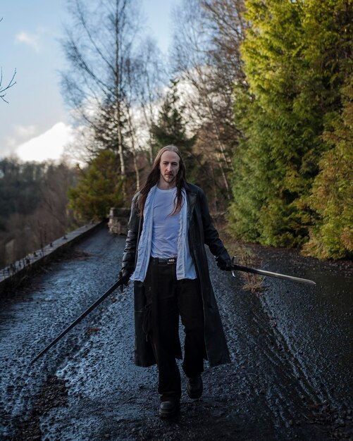 Photo full length of man holding swords on walkway