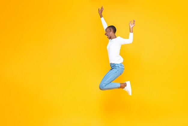 Full length of man jumping against yellow background