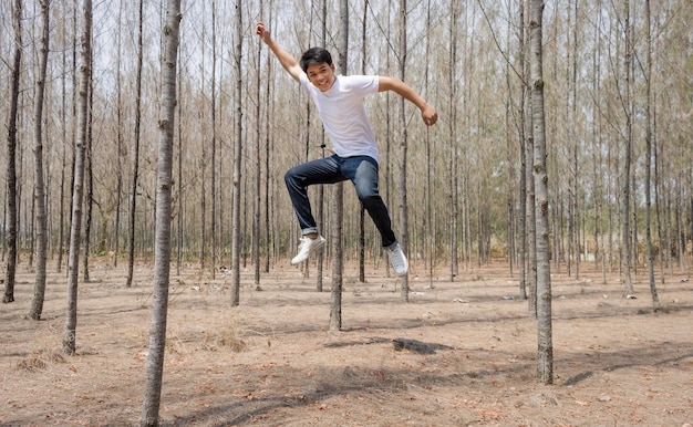 Foto lunghezza completa di un uomo che salta nella foresta