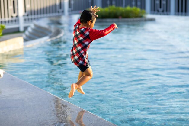 Photo full length of man jumping in swimming pool