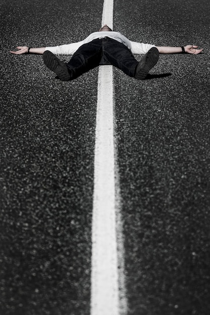 Foto lunghezza intera di un uomo sdraiato sulla strada