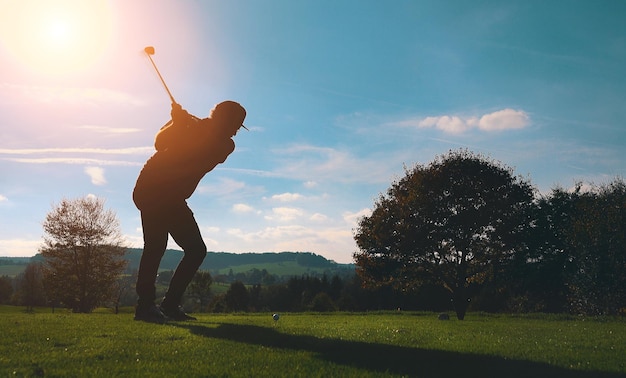 Full length of man playing golf on field against sky