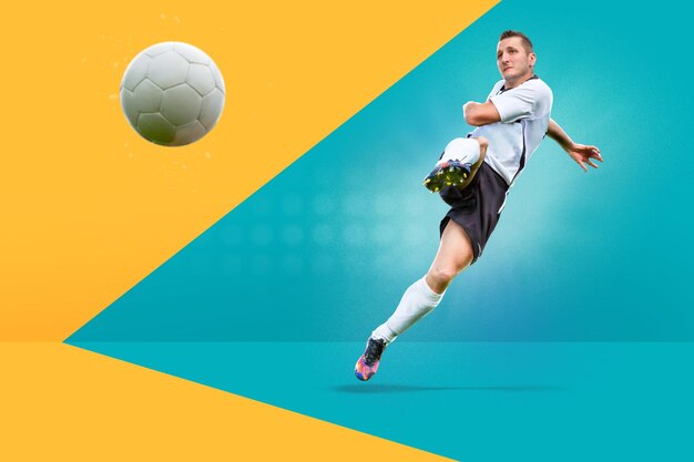 Full length of man playing soccer against colored background