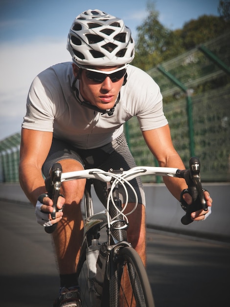 Foto lunghezza completa di un uomo in bicicletta sulla strada con la ringhiera