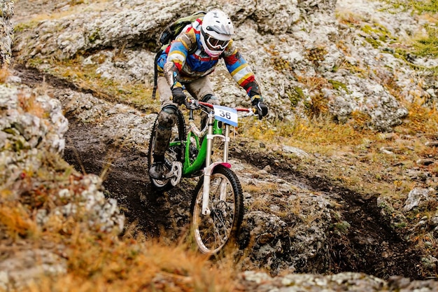 Full length of man riding mountain bike on rocks