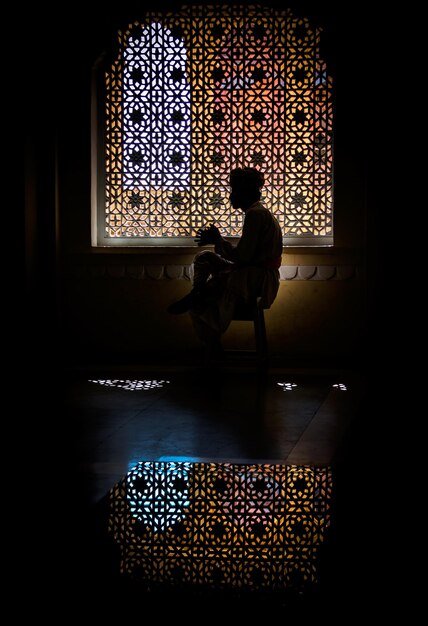 Photo full length of man sitting by window in historic fort