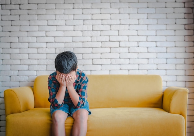 Full length of man sitting on sofa at home