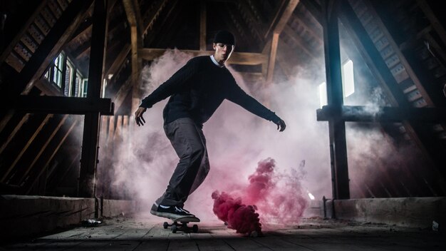 Photo full length of man skateboarding by red smoke