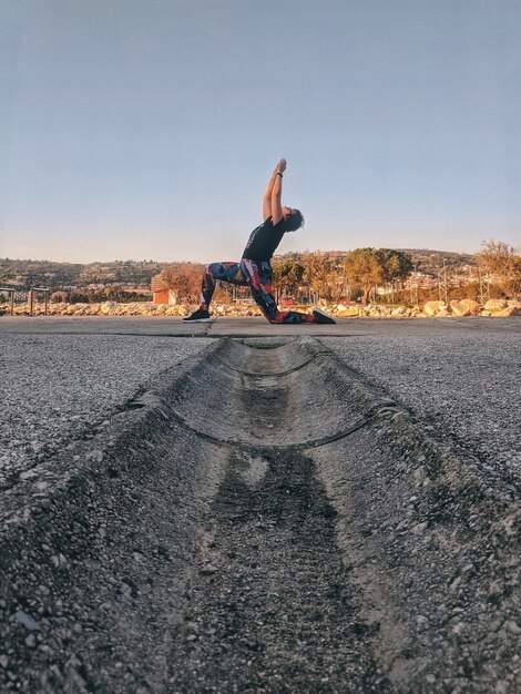 Full length of man skateboarding on road against sky