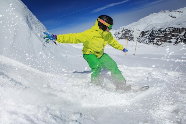 雪で覆われた山でスノーボードをしている男の全長