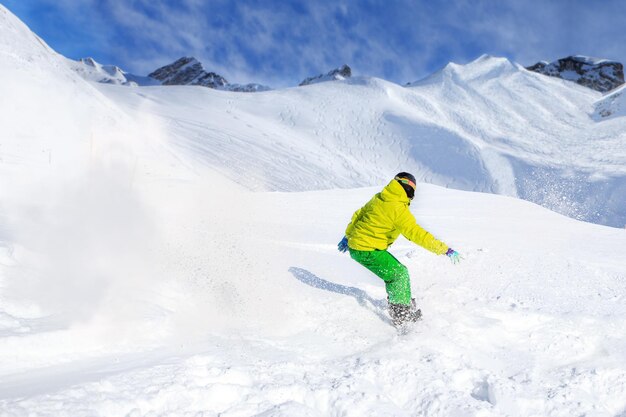 Full length of man snowboarding on snowcapped mountain