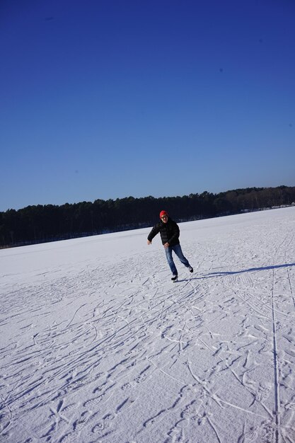 Full length of man on snowy field against clear sky