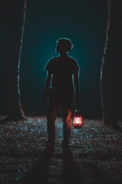 Foto lunghezza completa di un uomo in piedi su una lampada illuminata