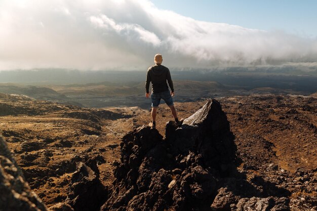 Photo full length of man standing on rock against sky