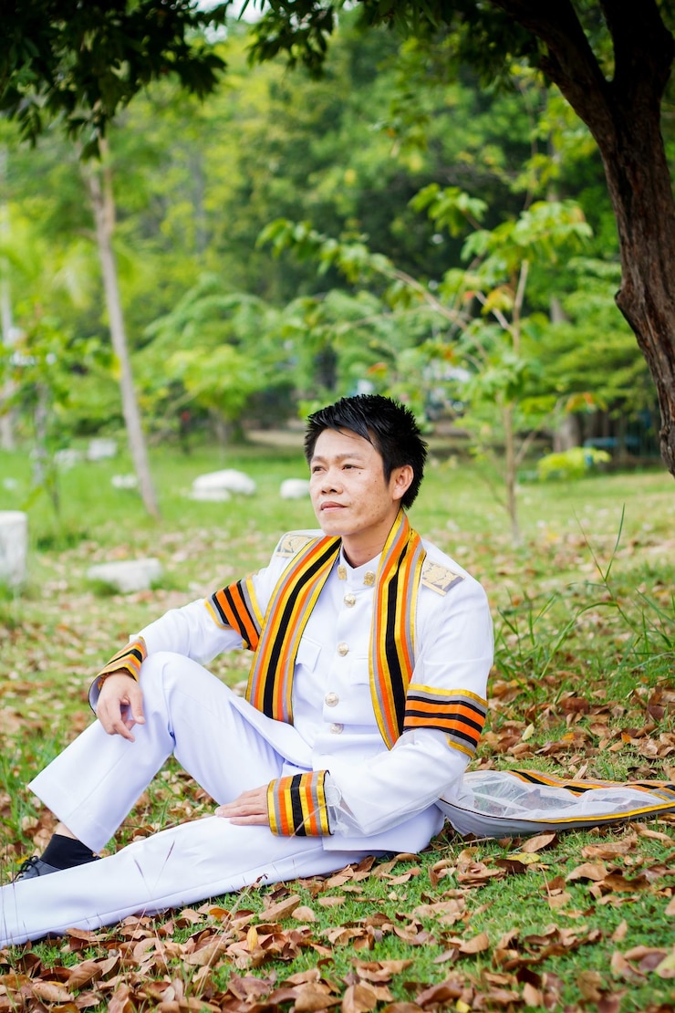 Photo full length of man in traditional clothing sitting on grass at park