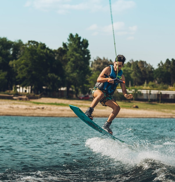 Foto lunghezza completa di un uomo che fa wakeboard in mare