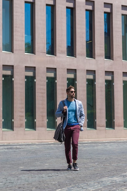 Photo full length of man walking by building in city