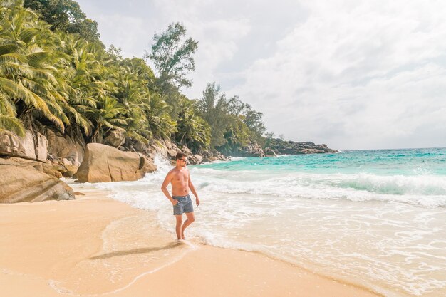 Photo full length of man walking on shore at beach against sky