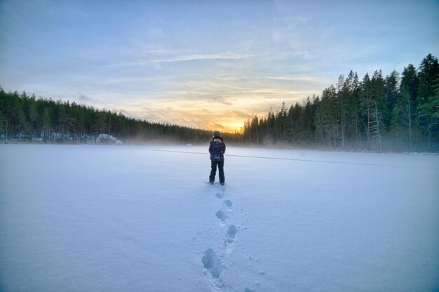 Full length of man walking on snow covered landscape