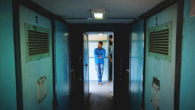 full length of man with arms crossed standing in train