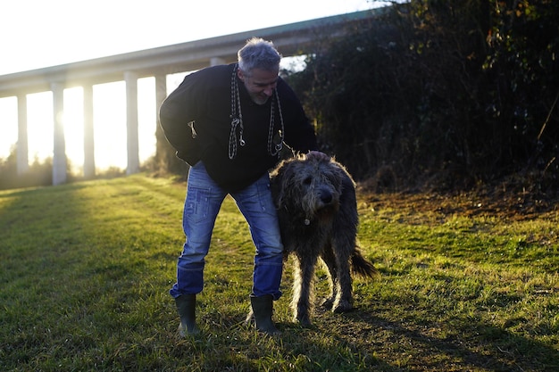 草の上で犬を飼っている男の全長