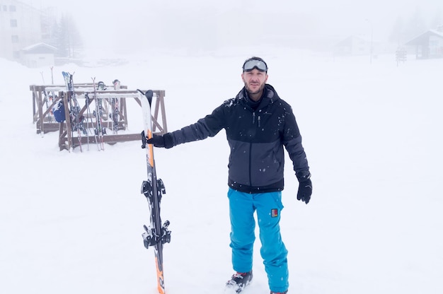 Foto lunghezza intera di un uomo con lo sci in mano