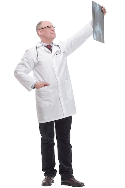 Вся длина. зрелый врач в белом халате шагает вперед. изолированные на белом фоне.