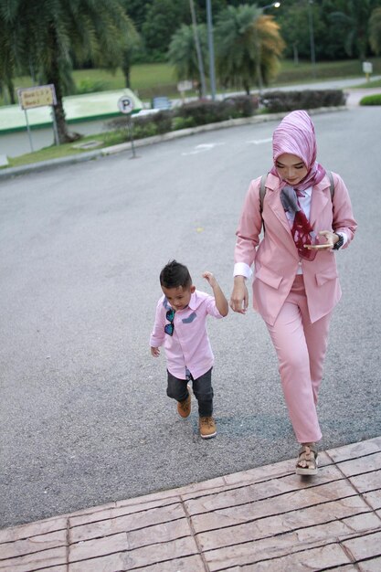 Full length of mother and daughter on footpath