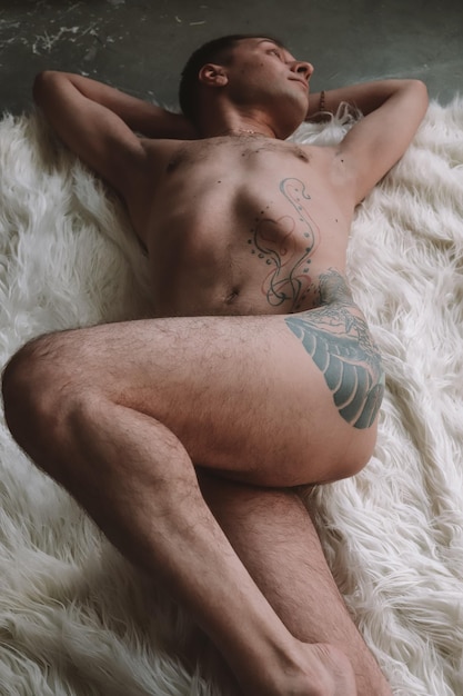 Photo full length of naked man lying down on fur