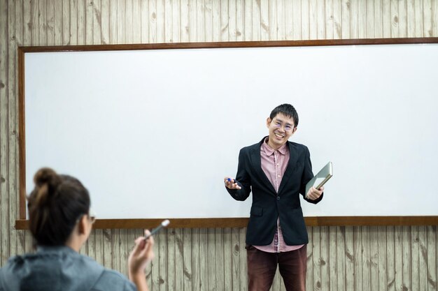 사진 벽에 서 있는 미소 짓는 젊은 여성의 전체 길이