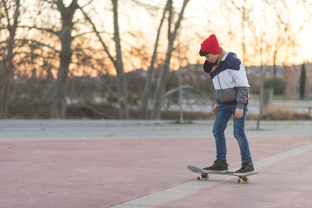 写真 道路でスケートボードをしている少年の全長