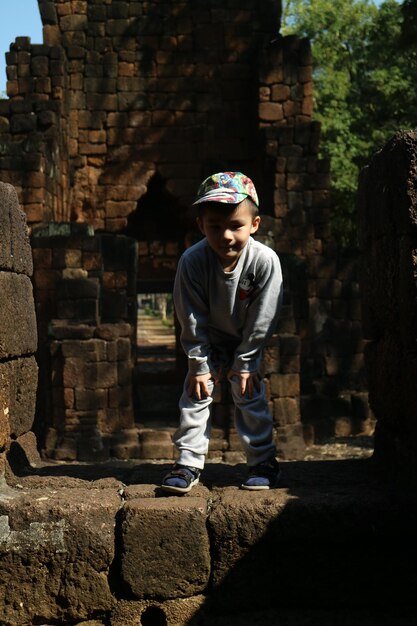 写真 石の壁に立っている男の子の全長