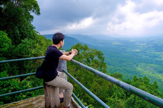 写真 天空を背景に山を見ている男の全長