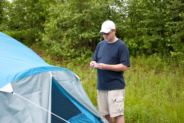 Фото Полный рост человека, стоящего возле палатки.