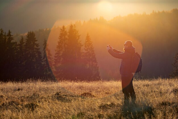 写真 夕暮れの空に向かって野原に立っている男の全長