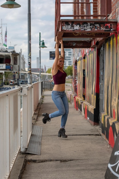 写真 街の歩道の遊び心のある幸せな女性の全長