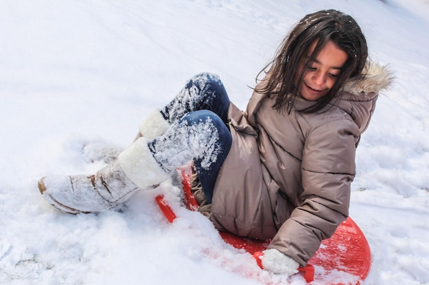Фото Полная длина улыбающейся девушки в снегу