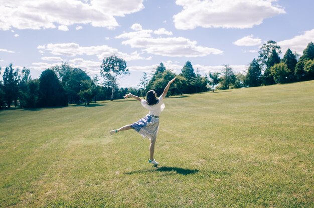 写真 空に向かってフィールドで踊る女性の全長