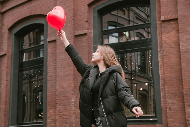 Фото Женщина в полной длине с воздушными шарами в окне в городе
