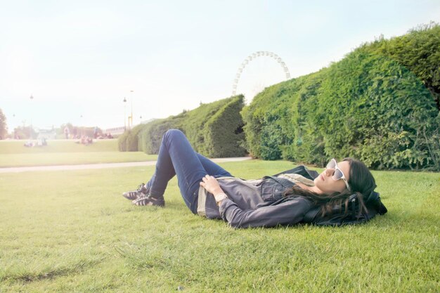 写真 公園の草の上に横たわっている女性の全長