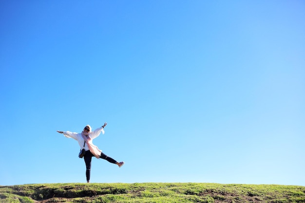 写真 澄んだ青い空を背景にフィールドの女性の全長