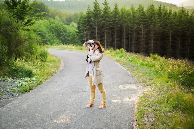 写真 道路に立って写真を撮っている女性の全長