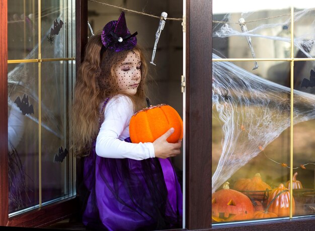 写真 カボチャのそばに立っている女性の全長