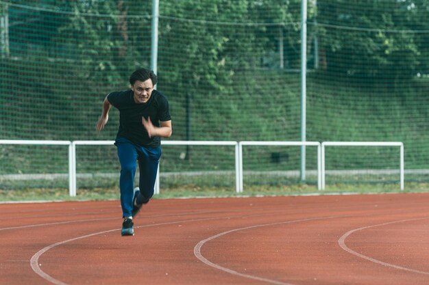 写真 トラックで走っている若者の全長