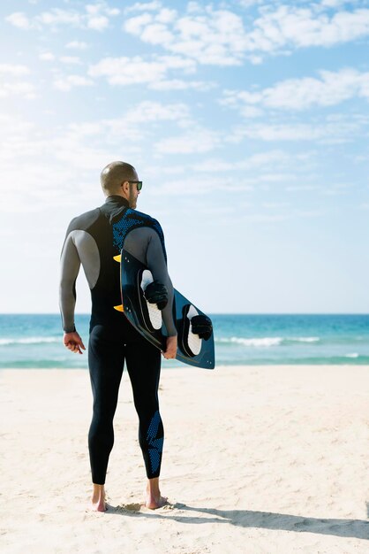 写真 浜辺に立っている若い男の全長