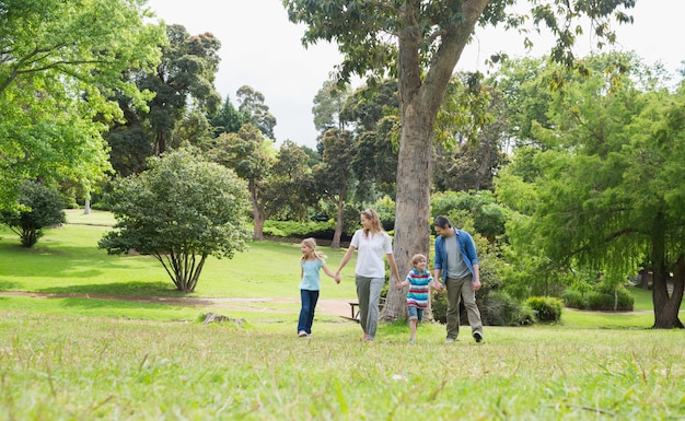 Foto lunghezza totale di genitori e bambini che camminano nel parco
