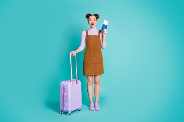 Full length photo of attractive pretty cute excited glad top knot hairstyle lady got visa ready trip abroad hold luggage wear purple sweater shoes brown dress isolated teal color background