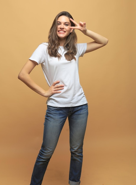 Full length photo of charming young woman in casual wear over beige background.