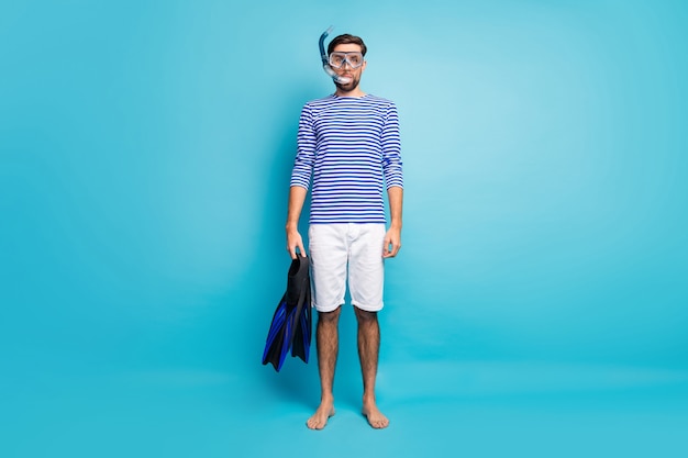 Full length photo of funny handsome guy tourist diving underwater mask breathing tube floating deep use flippers wear striped sailor shirt shorts isolated blue color